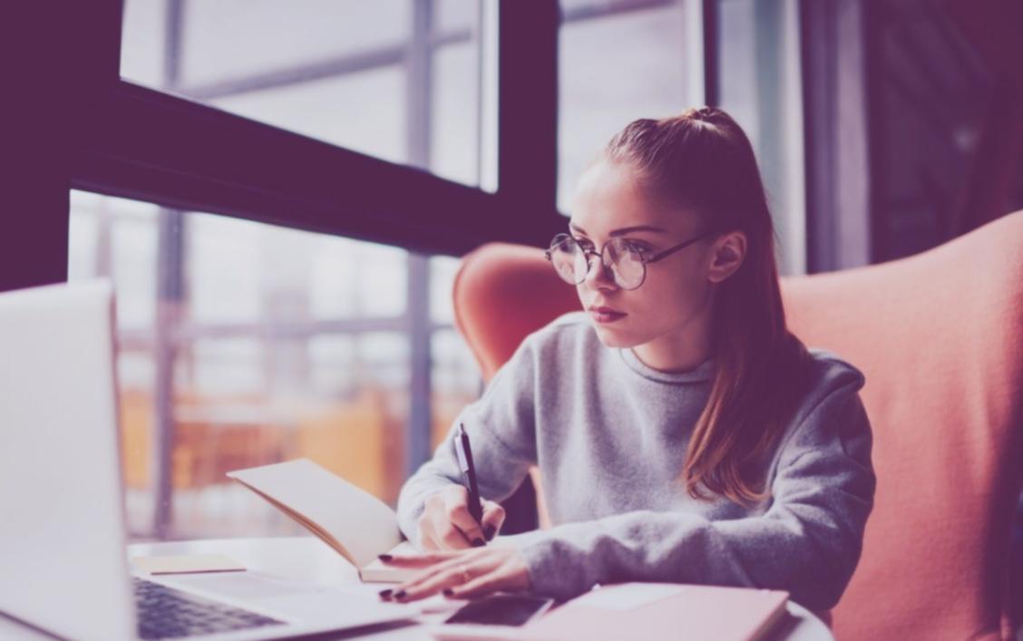 Business owner analyzing financial reports at desk with laptop